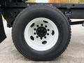 Close-up of a Michelin tire mounted on a white rim, showing the tread and bolt pattern, attached to a 2006 International 4200 truck