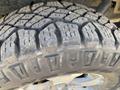 Close-up of a rugged tire tread of a 2014 Ford F-150 showcasing its grooves and patterns designed for off-road traction