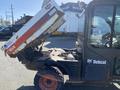 A 2015 Bobcat 5600 utility vehicle with a raised dump box showing a red and white color scheme and black wheels