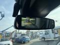A rearview mirror displaying a backup camera view from a 2016 Ford Transit 150 showing guiding lines for parking