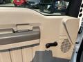 Interior view of the door panel of a 2009 Ford F-450 Super Duty featuring a handle speaker grille and control knob
