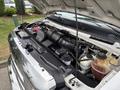 Engine compartment of a 2014 Ford E-350 showing the engine components and various fluid reservoirs