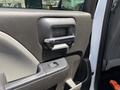 Close-up of the interior door handle and window controls of a 2020 Chevrolet Silverado