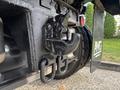 Close-up of a heavy-duty hitch attachment on a 2013 Freightliner 114SD with metal components visible and a tire in the background