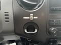 Interior dashboard controls of a 2014 Ford F-550 featuring lock and unlock buttons and air vent adjustment