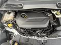 Close-up view of the engine compartment of a 2014 Ford Escape featuring the EcoBoost engine with various components and hoses visible
