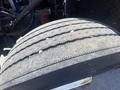 Close-up of a worn tire from a 1997 Freightliner FL70 showing visible tread wear and debris embedded in the rubber
