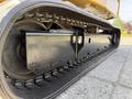 Close-up of the track assembly of a 2022 Caterpillar 306 showing the rubber track and metal components for traction and support