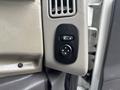 A control panel with a circular dial featuring arrows for adjusting windows in a 2013 International DuraStar 4300 cab