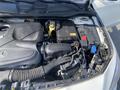 Close-up of the engine compartment of a 2014 Mercedes-Benz CLA-Class showing the engine cover battery and various components