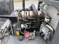 A detailed view of the engine compartment of a 2014 Wacker Neuson WL34 with various mechanical components including hoses and a battery