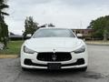 A 2016 Maserati Ghibli in white with a distinctive front grille and the Maserati logo prominently displayed on the hood
