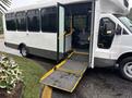 A 2018 Chevrolet Express bus with an open door and a fold-out ramp for accessibility