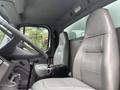 Interior of a 2006 Freightliner M2 106 showing two gray leather seats and a steering wheel with a battery visible on the floor