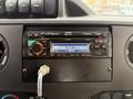 A 2014 Ford Econoline dashboard featuring a car radio with a display showing the station 92.9 MHz and the time 11:02 AM