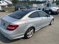 A silver 2013 Mercedes-Benz C-Class coupe parked with a sleek design and sporty wheels