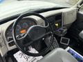 The interior of a 2013 International Workstar 7500 featuring a steering wheel with controls and a dashboard displaying multiple gauges and a digital screen