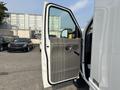 A 2008 Ford Econoline van with its driver's side door open, revealing a light gray interior and controls