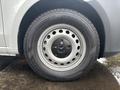 A close-up of a wheel from a 2021 Mercedes-Benz Metris featuring a silver metal rim and a black tire with tread patterns