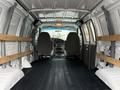 Interior view of a 2006 Ford Econoline van showing two front seats and wooden supports along the sides of the cargo area with a black floor surface