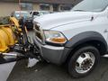 A 2011 Dodge Ram 5500 with a plow attached to the front, featuring a white body and large tires, positioned for snow removal