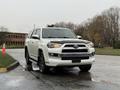 A 2018 Toyota 4Runner in white with a black hood and accents parked with wet pavement reflecting the vehicle