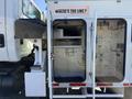 A 2008 International 7500 truck with an open utility compartment displaying shelves and storage space inside