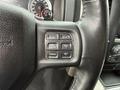 A close-up of the steering wheel controls in a 2018 RAM 1500 featuring buttons for gear selection and cruise control settings