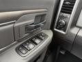 Close-up of the door handle and control panel of a 2018 RAM 1500 featuring window controls and a speaker grille