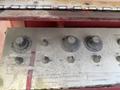 A control panel featuring several worn knobs and switches labeled for speed, retract, extend, rise, lower, and on/off functions