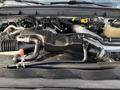 Engine components of a 2015 Ford F-550 with various hoses and pipes visible in the foreground