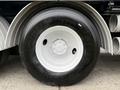 A large black tire with a white rim labeled with tire specifications and a visible hub on a 2013 International Workstar 7500 truck