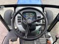 Close-up of the steering wheel and control panel of a 2009 New Holland T4020 tractor displaying various switches and gauges