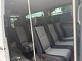 Interior of a 2009 Dodge Sprinter Van featuring several rows of black and gray upholstered seats with seat belts