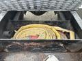 A rolled yellow fire hose placed inside a black compartment of a 2006 Freightliner M2 106 truck