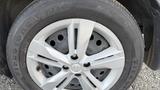 A close-up of a silver alloy wheel from a 2019 Nissan Kicks with a black tire branded with Firestone FT140