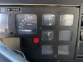 Dashboard of a 1991 International 4600 showing gauges for speed, fuel, and brake pressure along with indicator lights and a warning for the parking brake