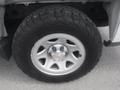 Close-up of a silver wheel rim with a Chevrolet logo mounted on a rugged black tire featuring an aggressive tread pattern