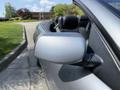 A silver 2004 BMW 6-Series convertible seen from the side focusing on the side mirror and part of the vehicle's body