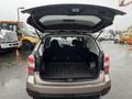 A 2016 Subaru Forester with the rear hatch open reveals a spacious cargo area featuring a flat loading floor and no visible contents