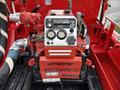 A Tohatsu V40B5X engine with a red exterior featuring dials, switches, and hoses mounted on a red platform