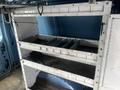2009 Ford Econoline van interior with metal shelving unit displaying several compartments for storing equipment and supplies