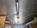 Interior ceiling view of a 2007 Morgan Olson Workhorse W42 with metal tracks and pipes mounted above shelves in a work vehicle
