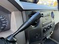 A 2009 Ford F-550 with a gear shift lever and dashboard controls visible in the foreground including gauges and air conditioning vents