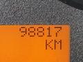 An odometer reading showing 98817 KM on an orange background