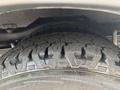 A close-up view of a rugged tire with a deep tread pattern from a 2020 Chevrolet Express