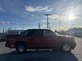 A red 2011 Chevrolet Avalanche with a black bed cover captured from the side showcasing its bold design and chrome wheels