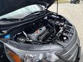 A 2014 Honda CR-V with its hood raised showcasing the engine compartment including various components like the battery and hoses