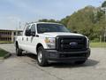 A white 2011 Ford F-350 SD pickup truck is parked with a black front grille and chrome accents