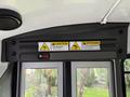 A 2013 Chevrolet Express interior view featuring warning signs mounted on the overhead panel including a caution sign and a trip hazard alert
